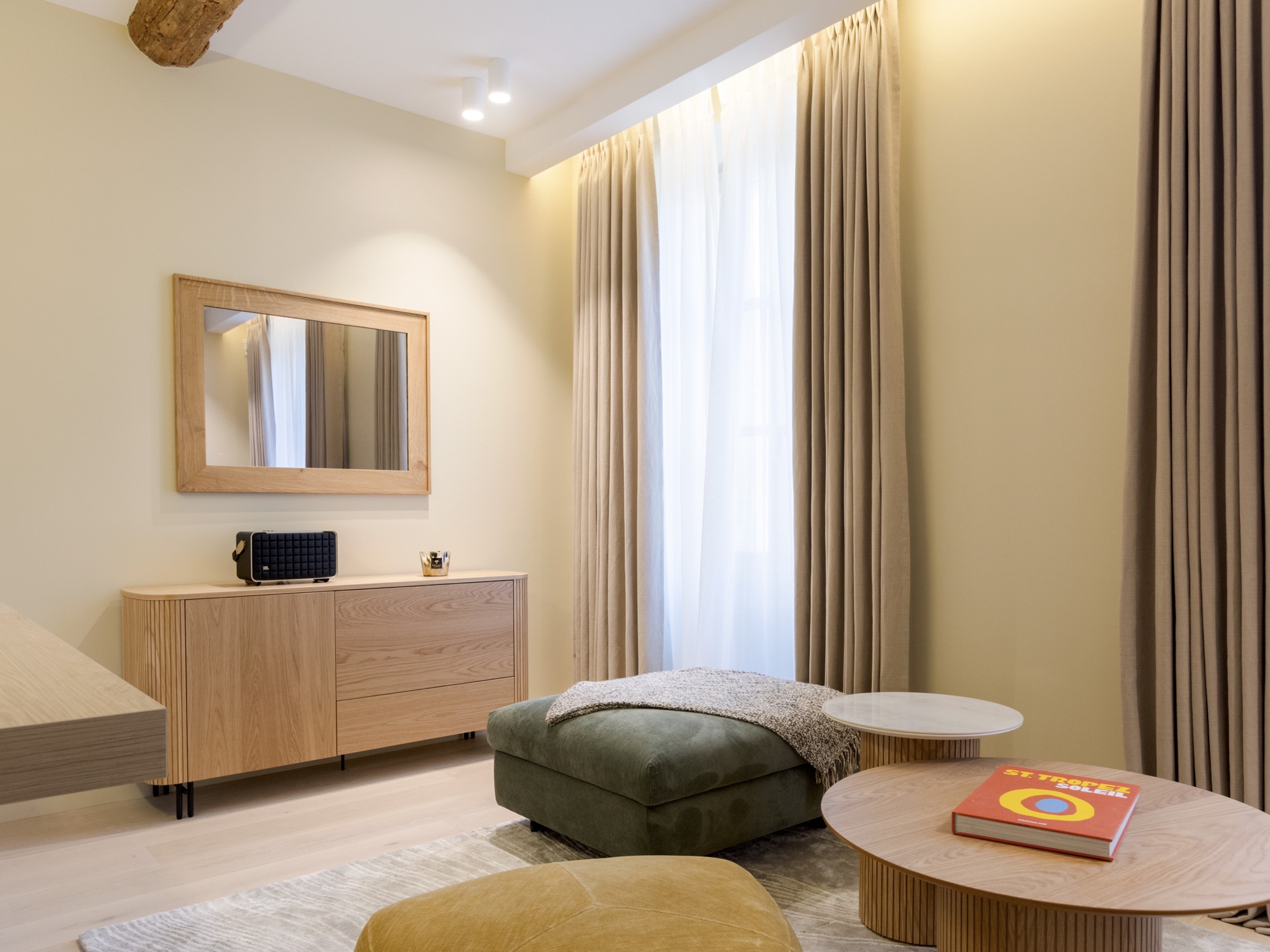 Salon lumineux avec rideaux et mobilier bois