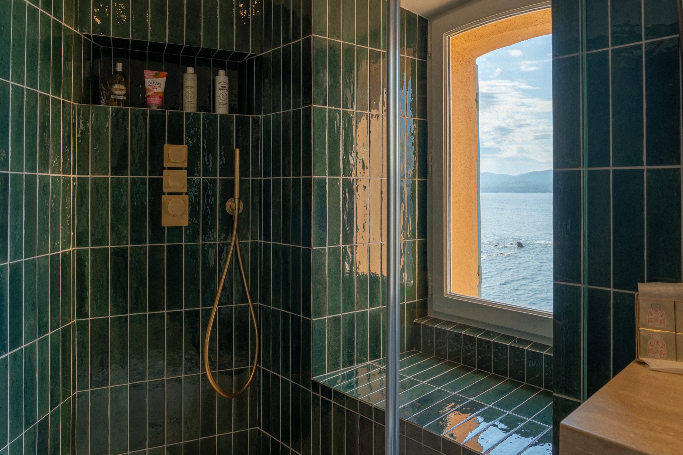 Salle de bain en zellige vert avec vue mer dans l'appartement à Saint-Tropez