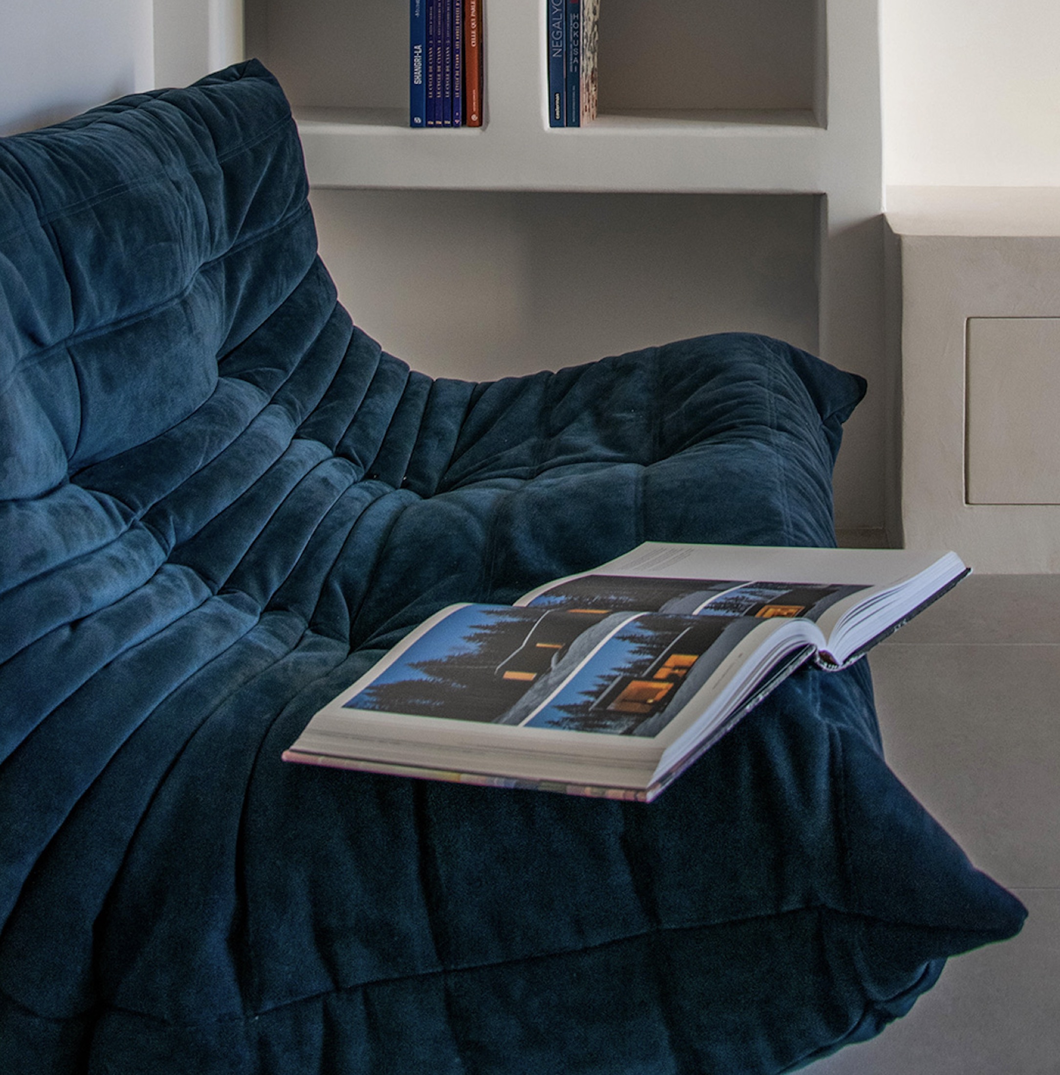 Fauteuil bleu et livre ouvert dans la Villa Cosy